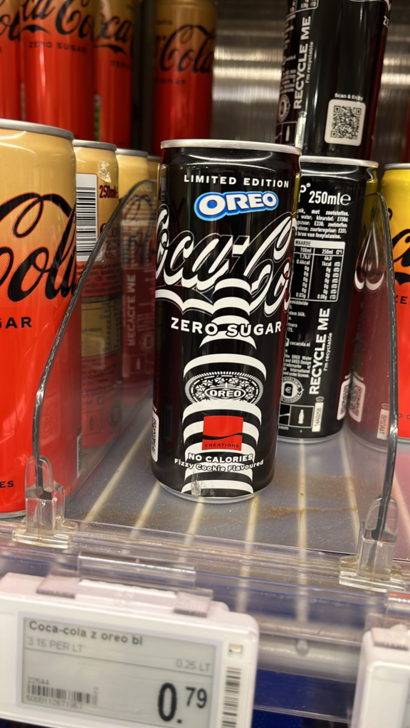 Several cans of Limited Edition Oreo Coke Zero in a supermarket display. The can has a black and white design on it of circular Oreo-like shapes stacked to resemble a Coke bottle. They're 79 cents a can.