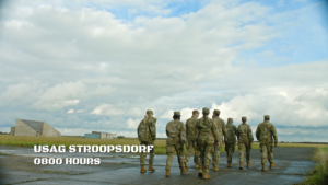 An establishing shot. Eight soldiers walk across an abandoned airfield. The horizon is flat as can be.